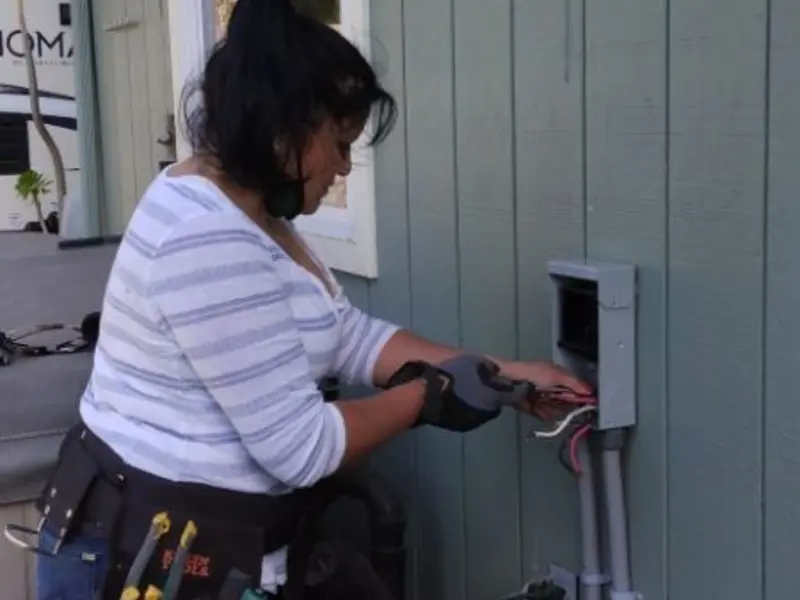 Licensed electrician wiring an exterior subpanel in Brazil
